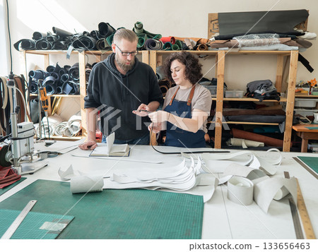 A man and a woman work as tanners in a workshop.  133656463