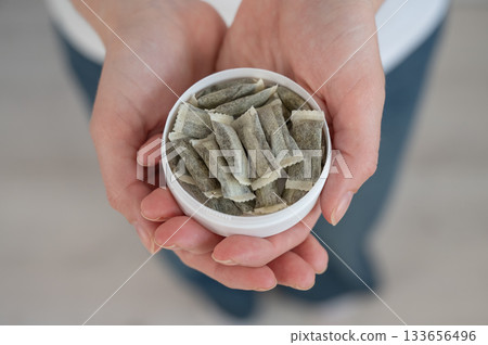 A woman holds a jar of chewing tobacco. A woman holds a jar of chewing tobacco. 133656496