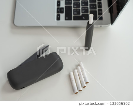 Tobacco heating system next to a laptop.  133656502
