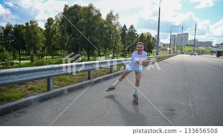 Caucasian woman rollerblading fast on road.  133656508