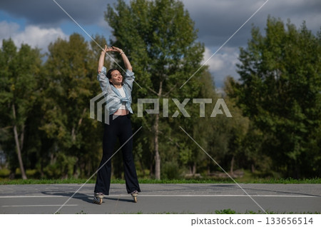 Caucasian woman roller skating in park. Caucasian woman roller skating in park. 133656514