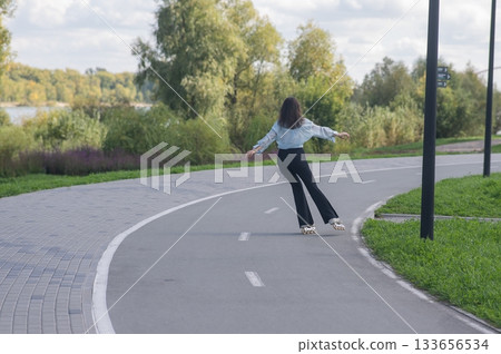 Caucasian woman roller skating in park. Caucasian woman roller skating in park. 133656534