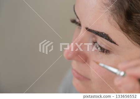 Caucasian woman getting eyebrow tinting procedure.  133656552