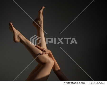 Woman applying moisturizer to her legs. Woman applying moisturizer to her legs. 133656562