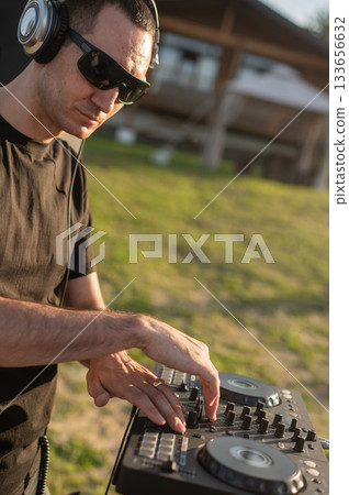 DJ works in the backyard of a country house.  133656632