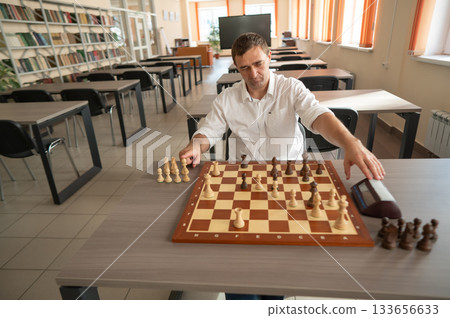Middle aged Caucasian man playing chess. Middle aged Caucasian man playing chess. 133656633