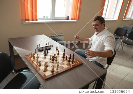 Caucasian man celebrates winning chess.  133656634
