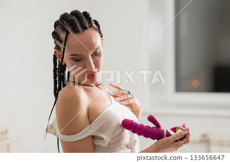 Caucasian woman holding a pink dildo. Caucasian woman holding a pink dildo. 133656647
