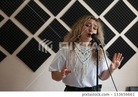 Caucasian woman singing into microphone in music studio.  133656661