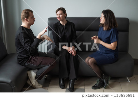 A man and two women are talking in Russian sign language.  133656691