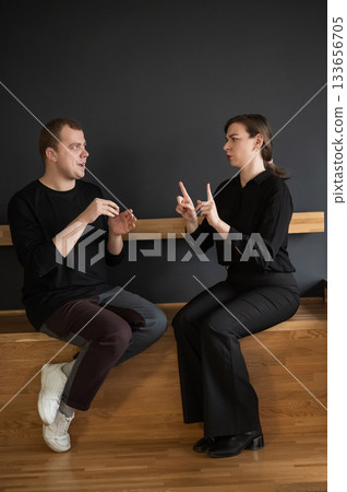 A man and a woman are talking in Russian sign language.  133656705