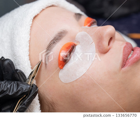 Caucasian woman undergoing eyelash lamination procedure. Caucasian woman undergoing eyelash lamination procedure. 133656770