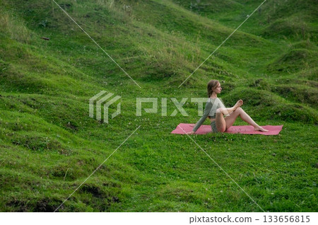 Caucasian woman doing yoga outdoors.  133656815