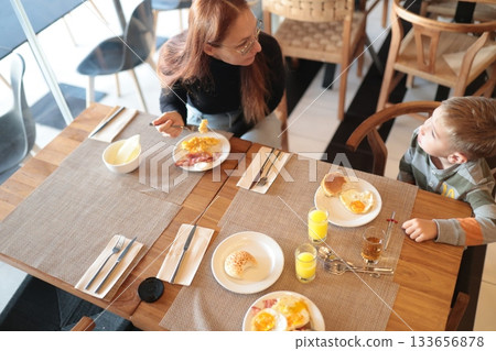 Mother and child enjoying hotel breakfast together 133656878