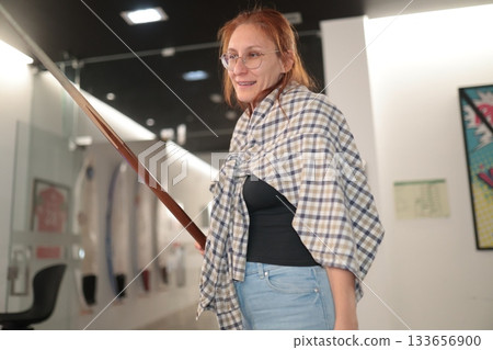 Woman smiling holding pool cue in billiards hall 133656900
