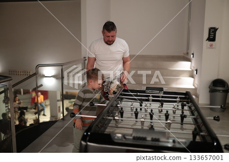 Father and son playing table football having fun 133657001