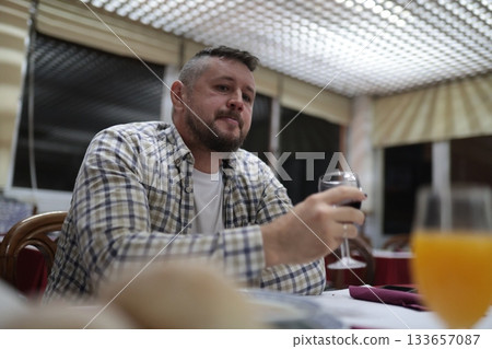 Man enjoying red wine and relaxed dinner at restaurant Man enjoying red wine and relaxed dinner at restaurant 133657087