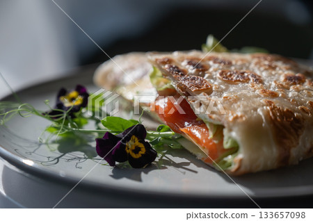 A flatbread stuffed with fish and cheese served in a cafe. Quesadilla. 133657098
