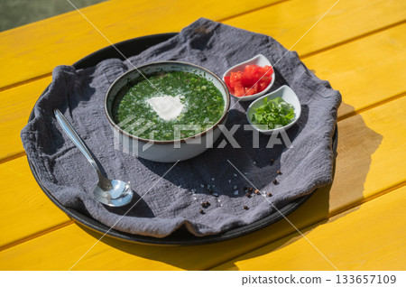 Traditional Russian lunch in a cafe. Top view of okroshka on a table in a summer cafe. Traditional Russian lunch in a cafe. Top view of okroshka on a table in a summer cafe. 133657109