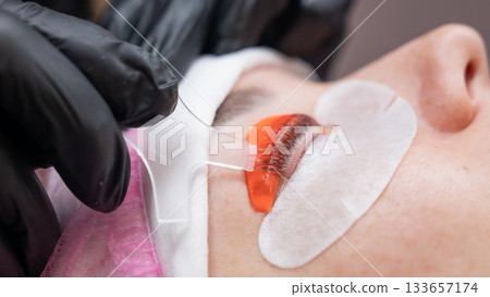 Caucasian woman undergoing eyelash lamination procedure.  133657174
