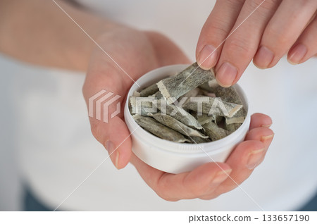 A woman holds a jar of chewing tobacco. A woman holds a jar of chewing tobacco. 133657190