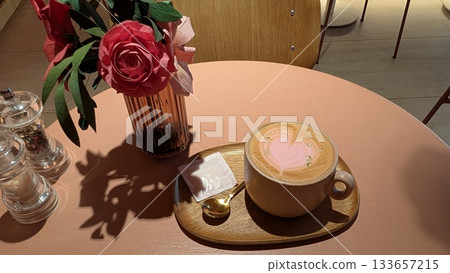 Pink latte with gold and paper rose on the pink table 133657215