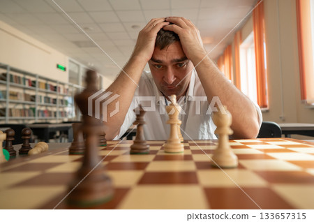 Middle aged Caucasian man playing chess. Middle aged Caucasian man playing chess. 133657315