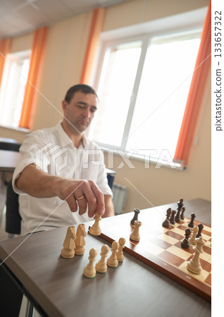 Middle aged Caucasian man playing chess. Middle aged Caucasian man playing chess. 133657322