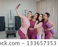 Two Caucasian and two Asian women take a selfie after a Pilates workout.  133657353