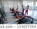 A trainer adjusts women on a reformer. 133657364