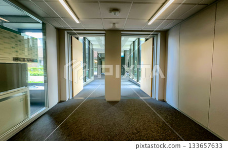 Empty workplace passageway surrounded by sleek design elements 133657633