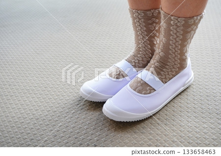 照片中可以看到她穿著乾淨的白色新室內鞋和花紋襪。 133658463