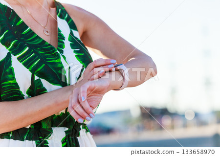Female touching her smartwatch Female touching her smartwatch 133658970