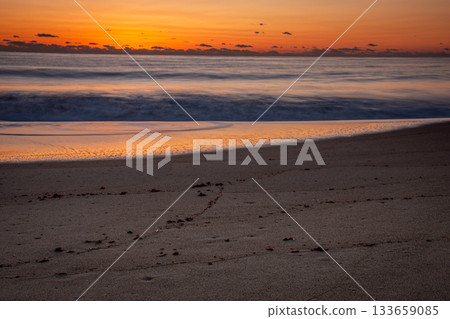 The winter seascape of Kawarago Coast, with waves lapping on the sand and the morning glow The winter seascape of Kawarago Coast, with waves lapping on the sand and the morning glow 133659085