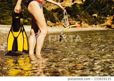 Woman with flippers snorkeling tube on beach Woman with flippers snorkeling tube on beach 133659135
