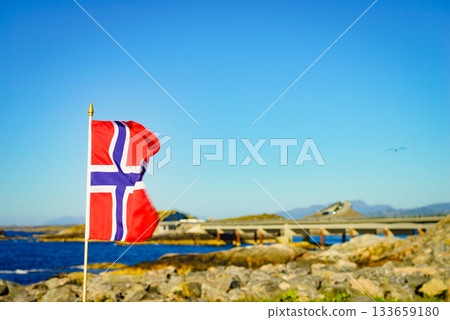 Norwegian flag against Atlantic Road, Norway 133659180