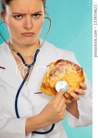 Dietitian examine sweet roll bun with stethoscope. 133659621