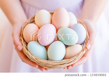 Colorful pastel eggs displayed beautifully in a woven basket held by hands during springtime festivities Colorful pastel eggs displayed beautifully in a woven basket held by hands during springtime festivities 133659991