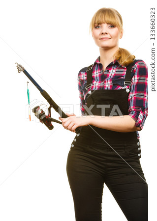 Similing woman wearing check shirt holding fishing rod Similing woman wearing check shirt holding fishing rod 133660323