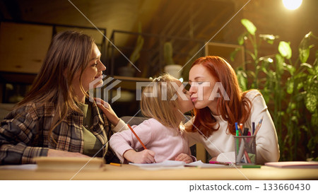 Little girl giving affectionate kiss on a cheek to mom during homework time 133660430