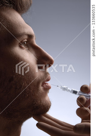 Specialist injecting filler to enhance male lip contour with precision 133660535