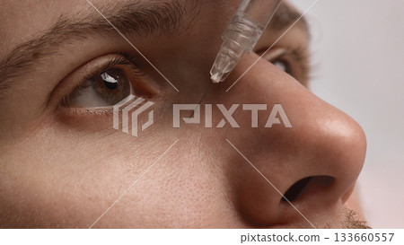 Doctor injecting filler under male eye to reduce hollowness and refresh appearance Doctor injecting filler under male eye to reduce hollowness and refresh appearance 133660557
