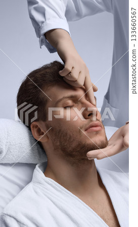 Doctor examining male nasal bridge and profile balance for rhinoplasty planning. Doctor examining male nasal bridge and profile balance for rhinoplasty planning. 133660567