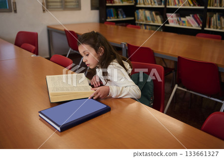 Focused Student Reading in Library During Quiet Study Time Focused Student Reading in Library During Quiet Study Time 133661327
