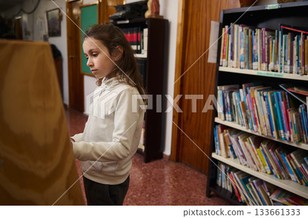 Girl Learning In Library: Focused Student By Bookshelves In A School Library 133661333