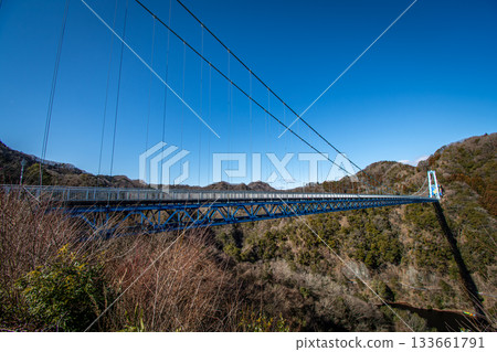 The magnificent scenery of Ryujin Suspension Bridge and Ryujin Gorge, shining against the blue winter sky (Ibaraki Prefecture) 133661791