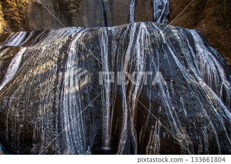 冬日的袋田瀑布:水流順著岩壁傾瀉而下,形成精緻的白色線條圖案。 冬日的袋田瀑布:水流順著岩壁傾瀉而下,形成精緻的白色線條圖案。 133661804