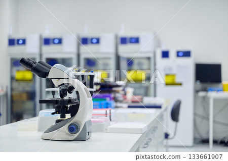 Microscope on laboratory bench in modern research facility with storage units 133661907