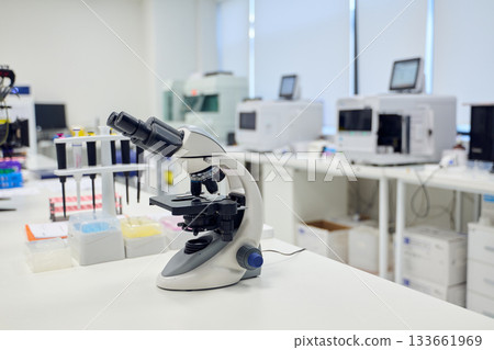 Microscope on lab counter surrounded by scientific equipment in a modern laboratory setting 133661969