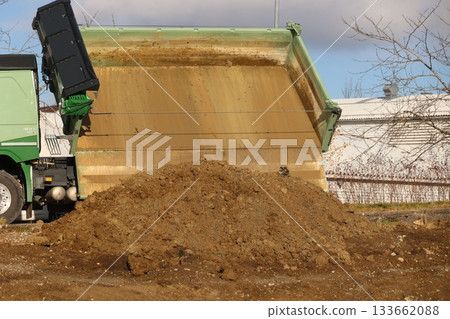 Dump truck unloading soil on construction site 133662088